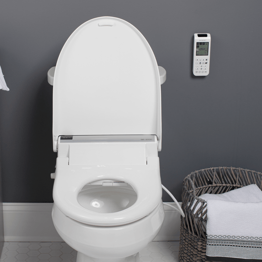 Bio Bidet BB-2000 Smart Bidet Toilet Seat with remote control mounted on the wall and accessories in basket.