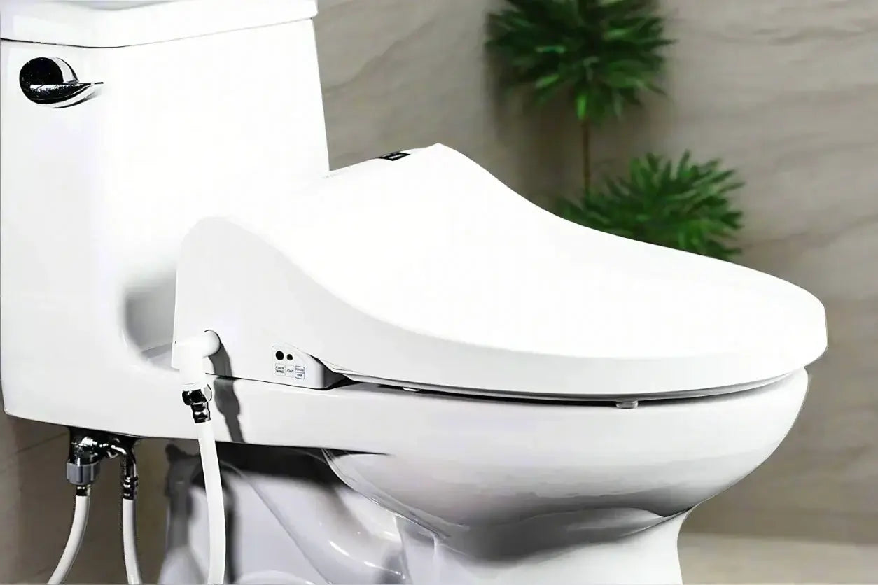 Blooming Bidet R1570 Smart Bidet Toilet Seat - Diagonal view of seat installed on toilet with lid down in bathroom with plant and beige walls