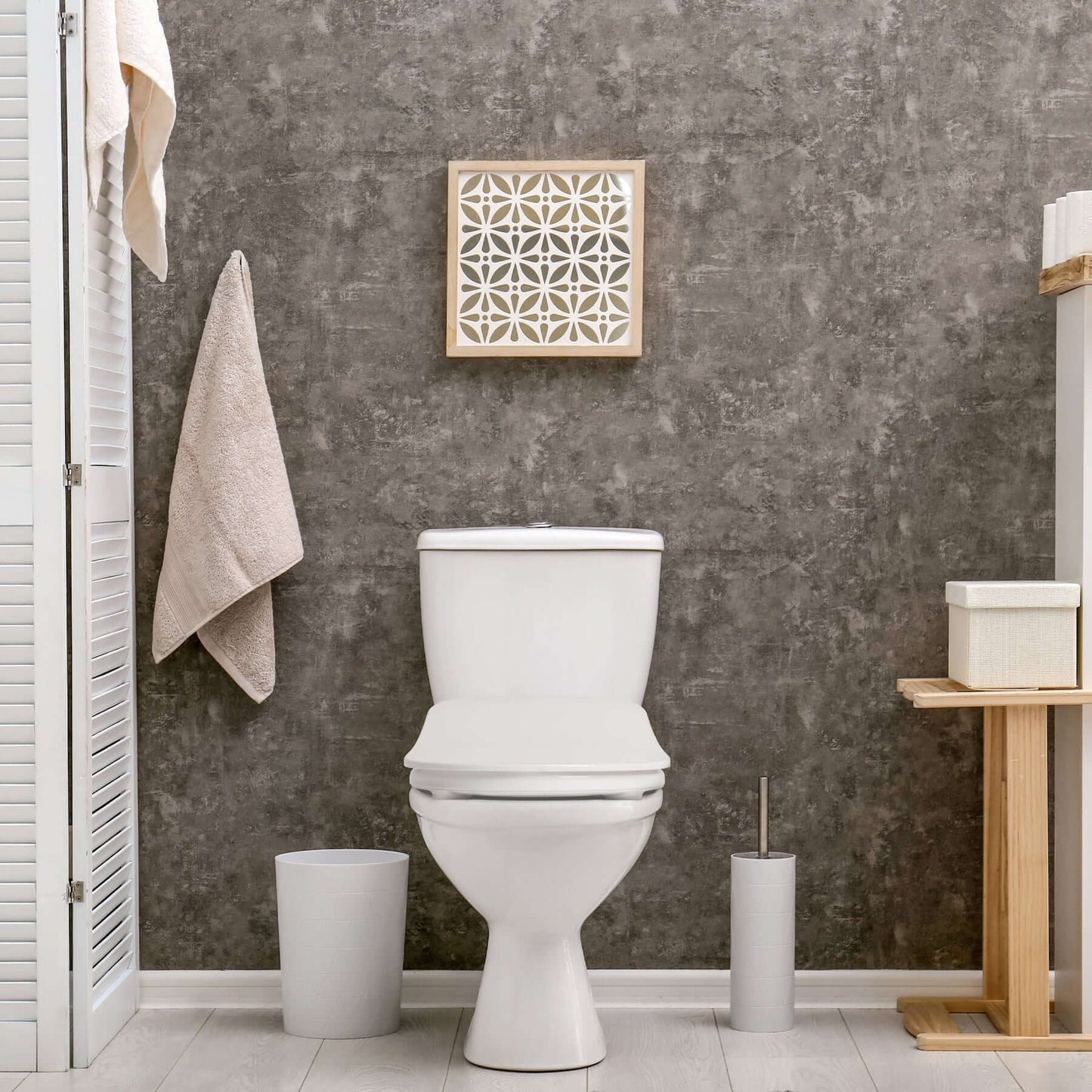 Modern bathroom scene featuring a toilet with decorative wall art and minimalistic decor.