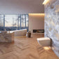 Toilet mounted on marble wall with night light shining below it